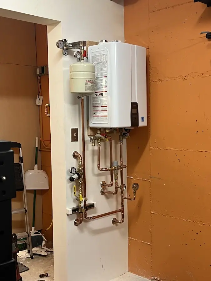 Plumbing technician inspecting water heater connections in Keokuk